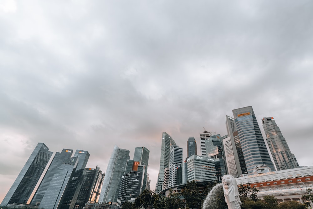 a statue of a bird in front of a city skyline