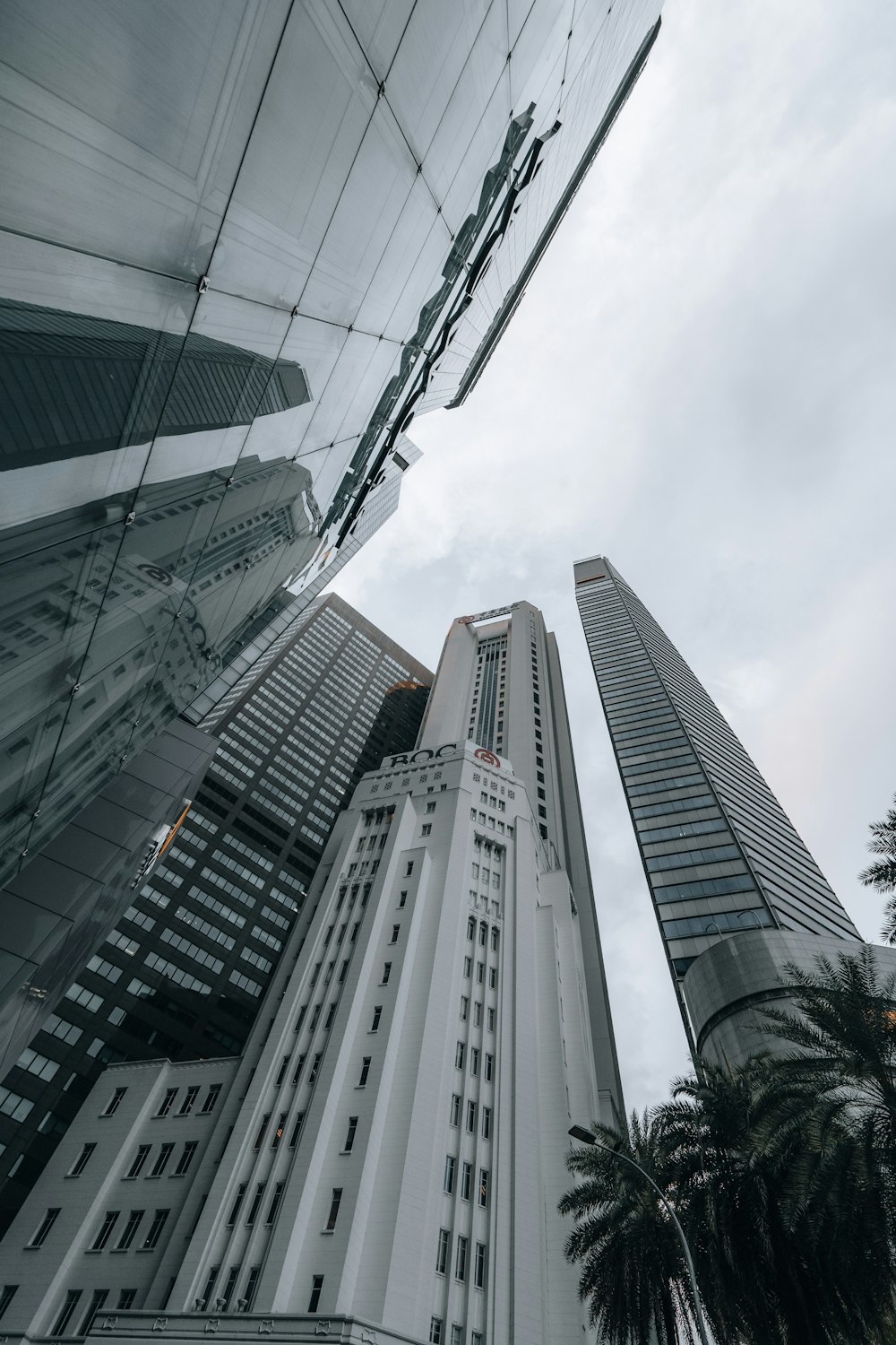 a tall white building with palm trees in front of it