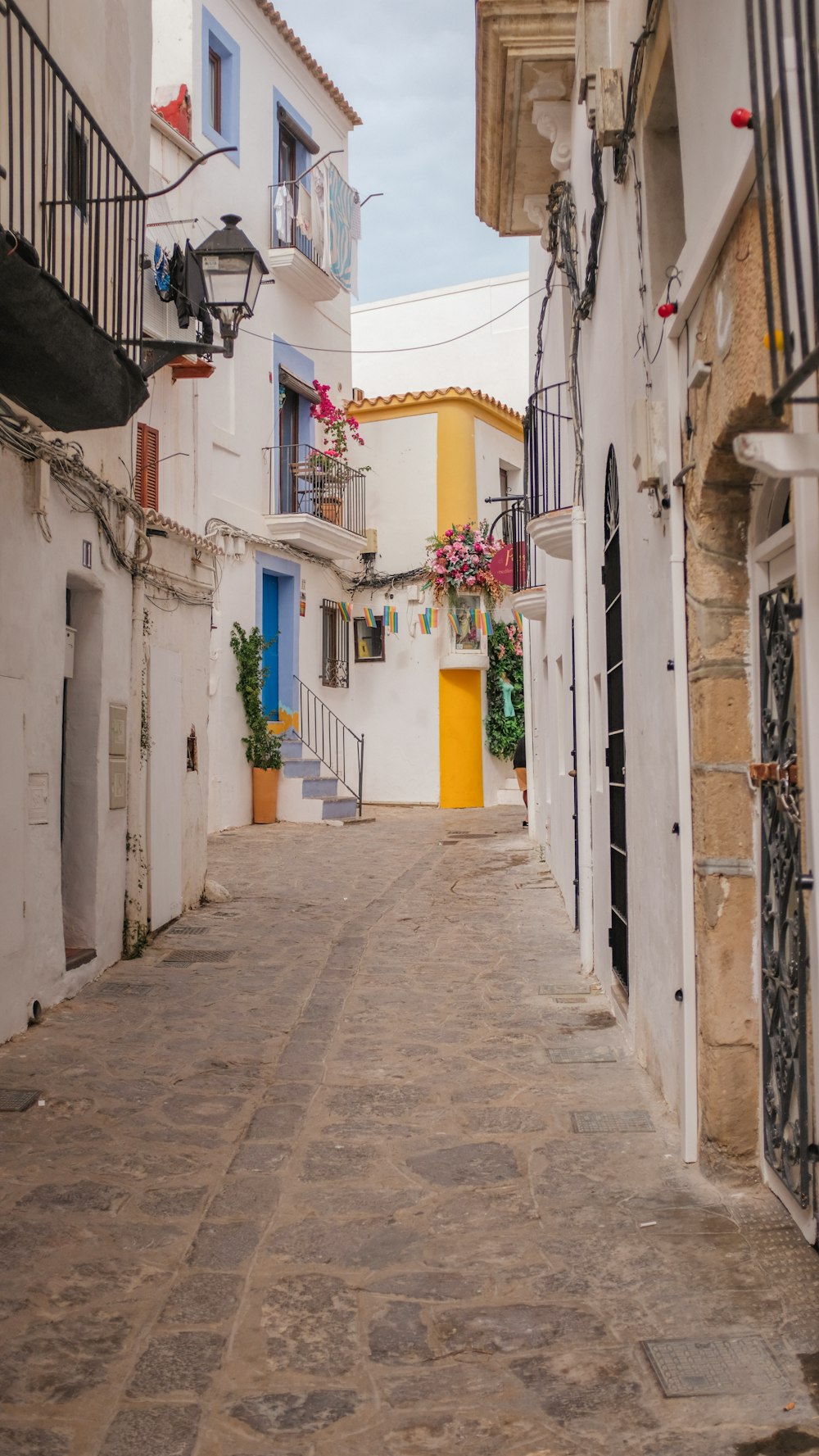 a narrow street with white buildings and blue doors