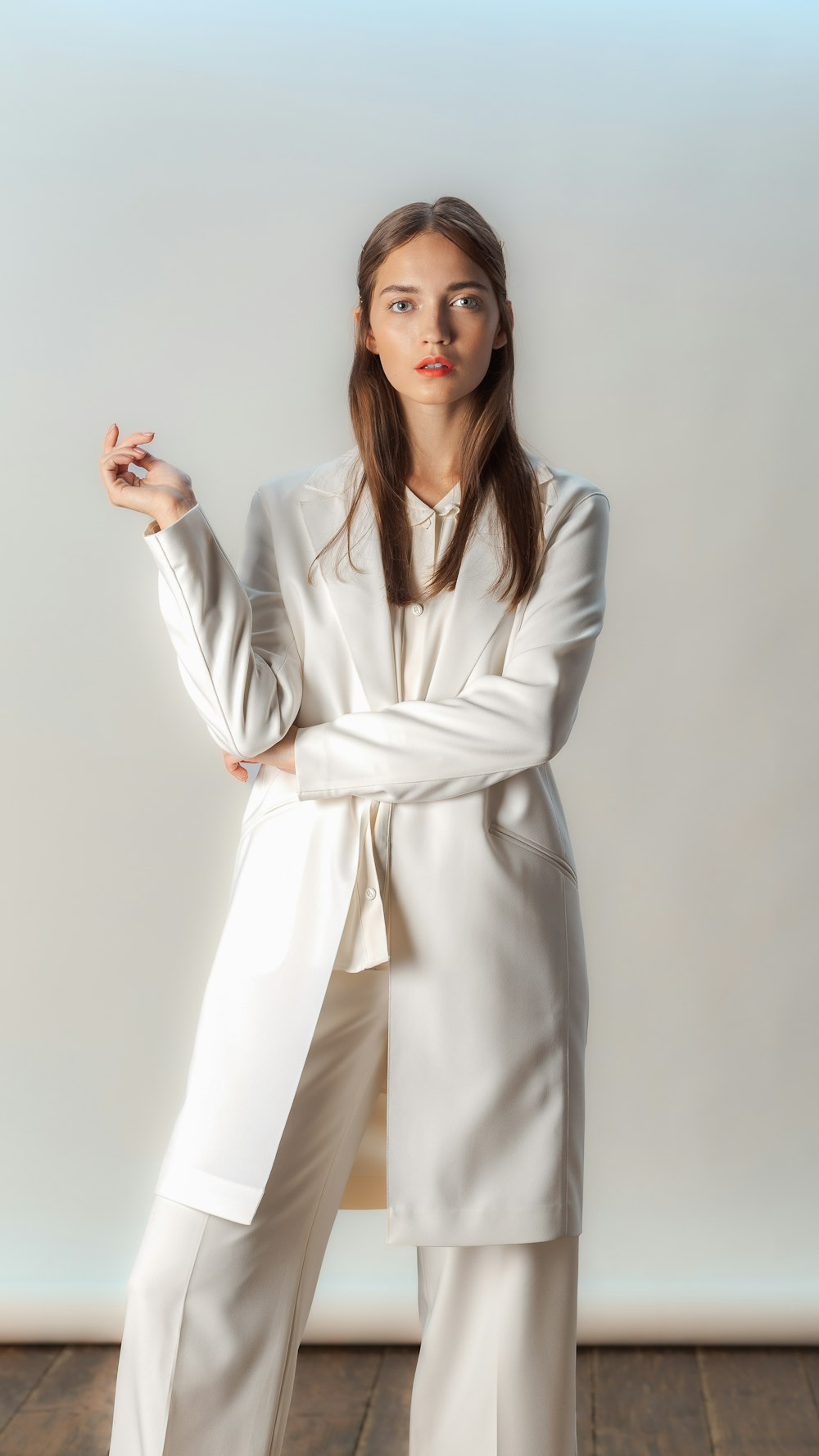 a woman in a white suit posing for a picture