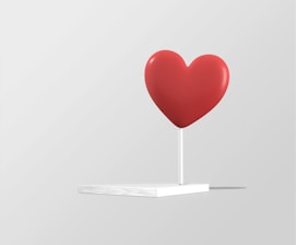 a red heart on a white stand