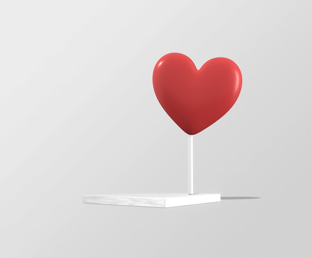 a red heart on a white stand