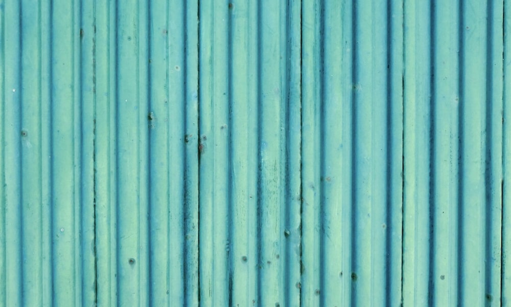 a close up of a blue metal wall