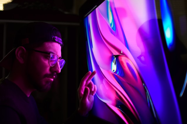 Portrait of George Xygkos working thoughtfully with data visualizations on screen.