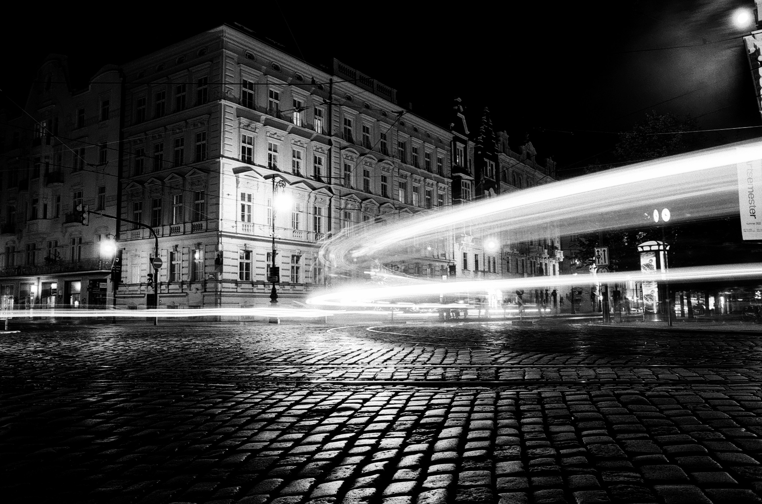 Una foto en blanco y negro de una calle de la ciudad por la noche