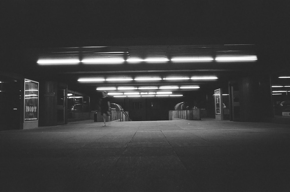 a black and white photo of a walkway at night
