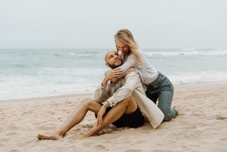a man holding a woman on the beach