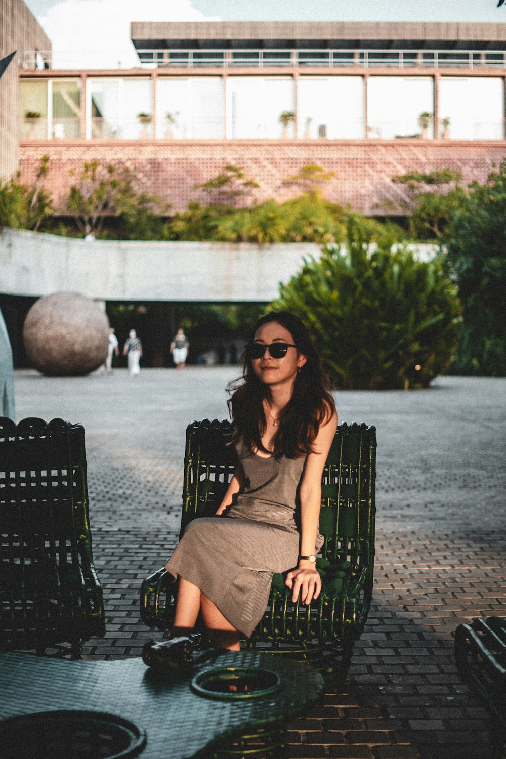 a woman sitting on a bench in a courtyard