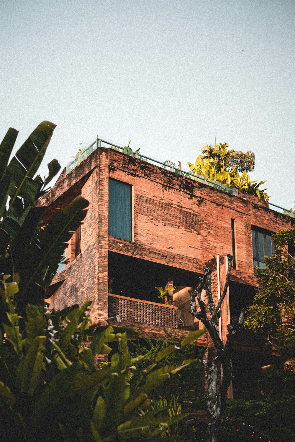 a tall brick building with a green roof