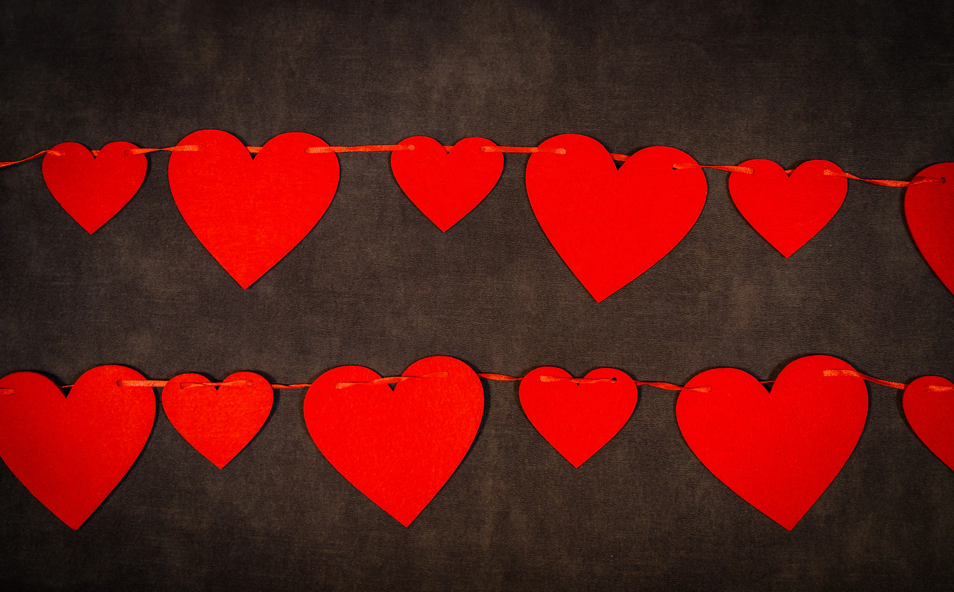 a bunch of red hearts hanging on a string