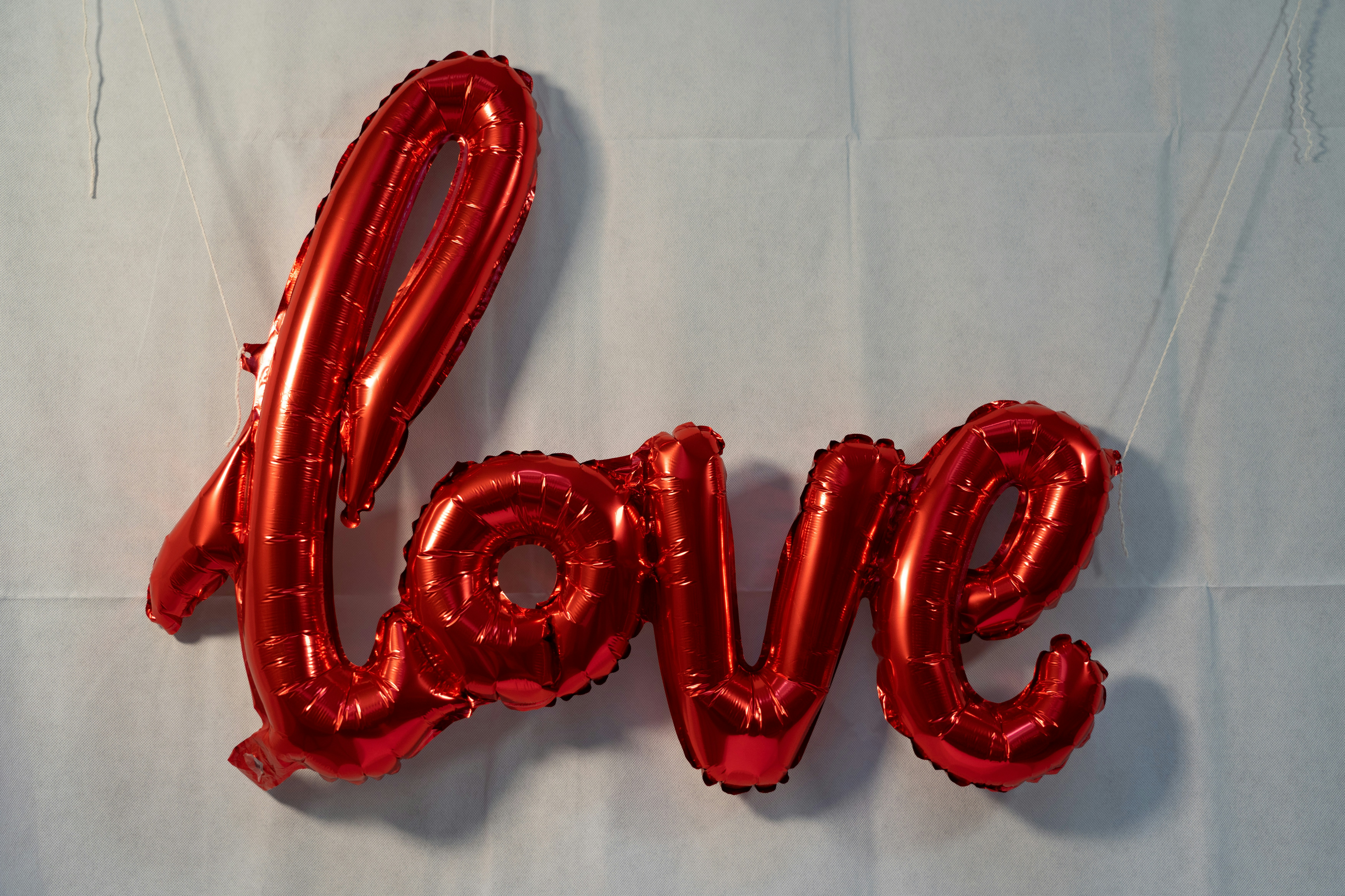 a red balloon spelling love on a white background