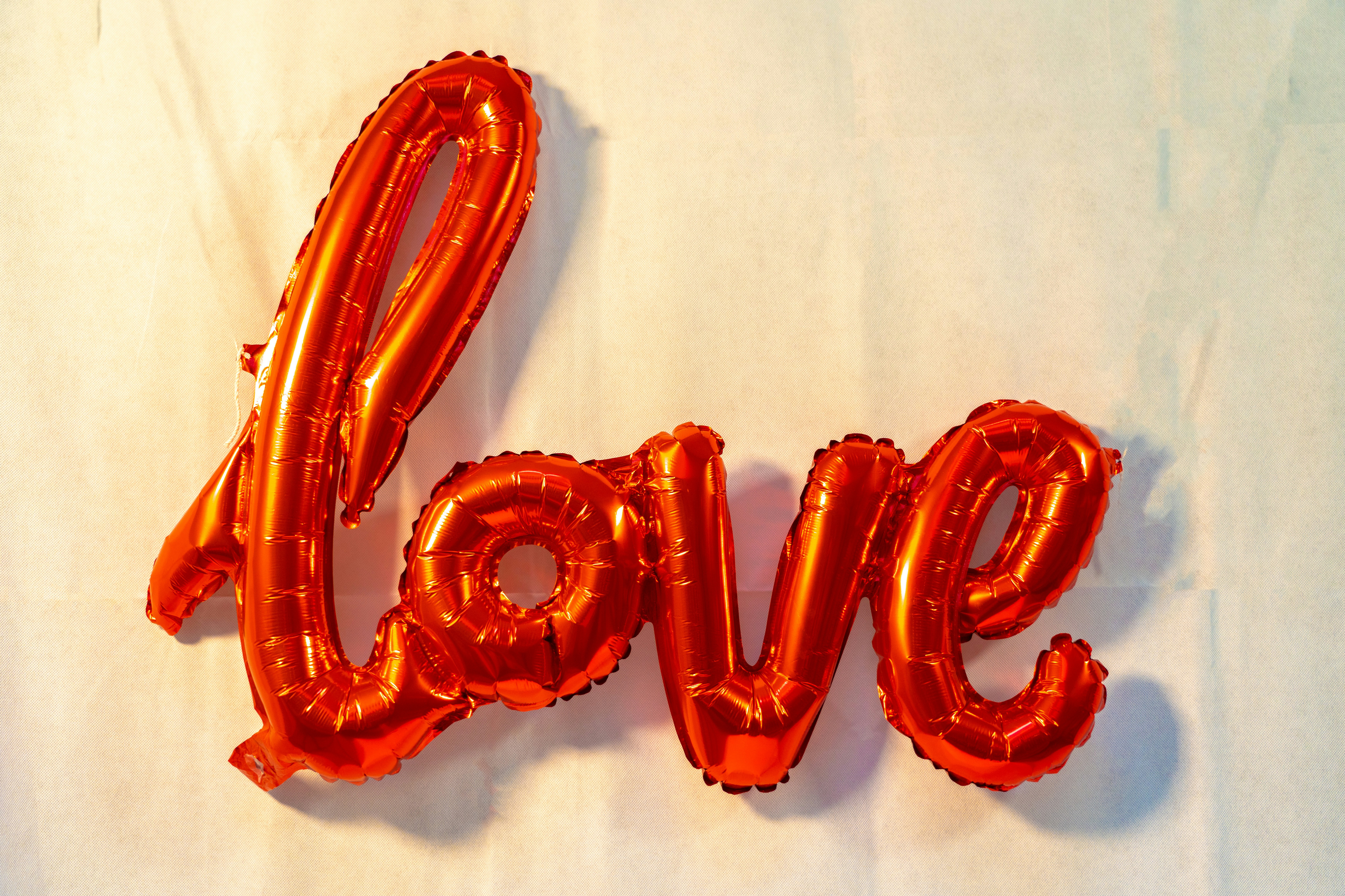 the word love spelled out of balloons on a sheet of paper