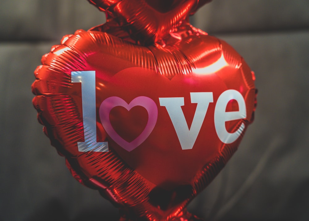 a heart shaped balloon with the word love on it