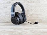 A collection of gaming headsets on a wooden table.