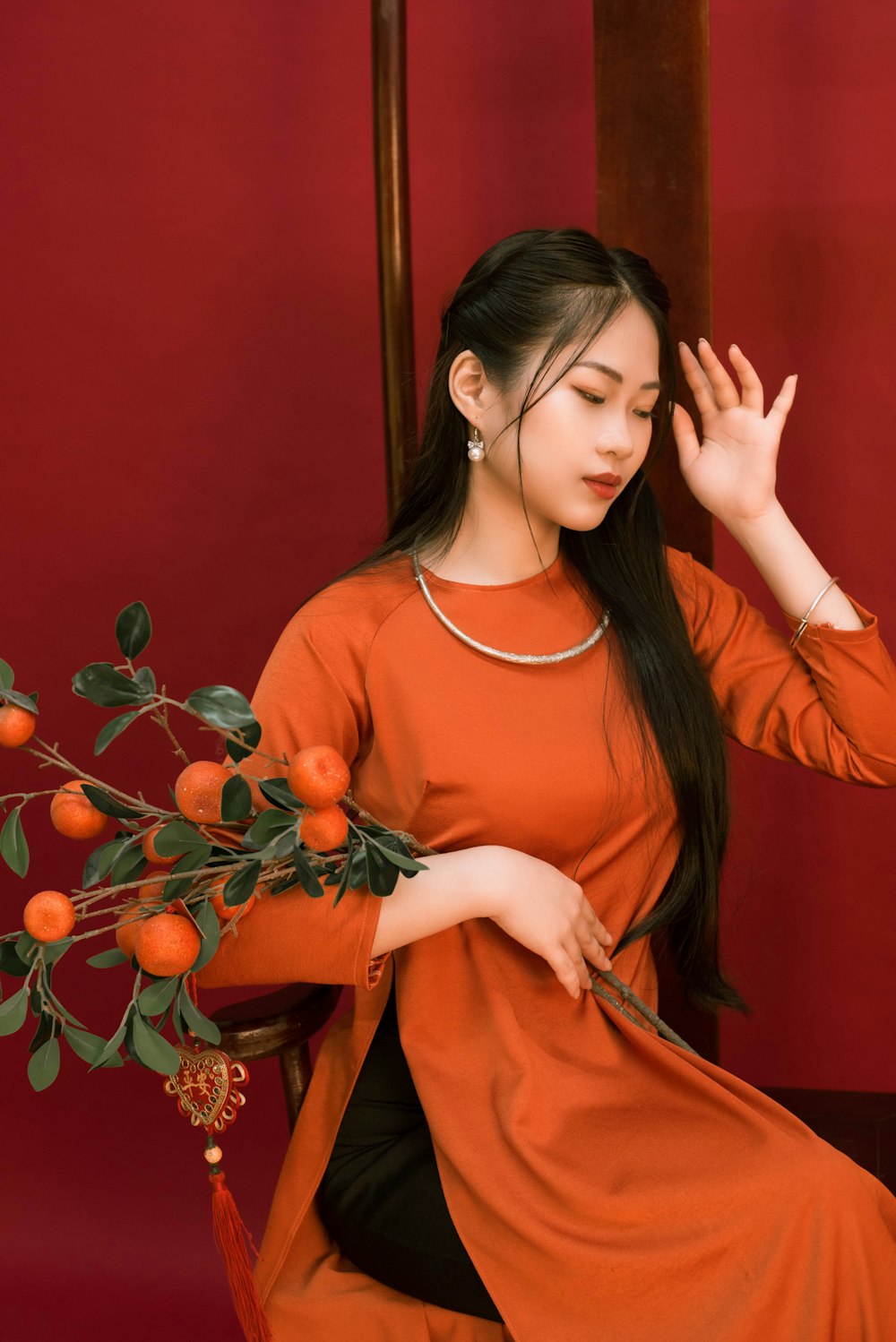 a woman sitting on a chair holding a bouquet of oranges