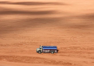 a truck is parked in the middle of a dirt field