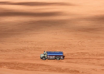 a truck is parked in the middle of a dirt field
