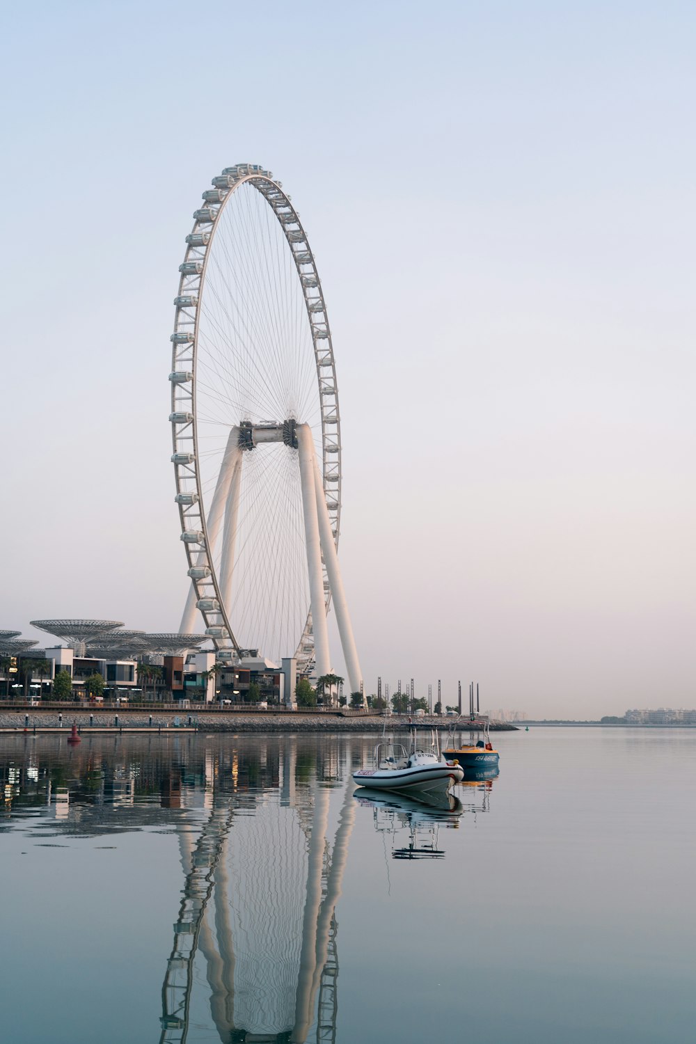 a large ferris wheel sitting next to a body of water