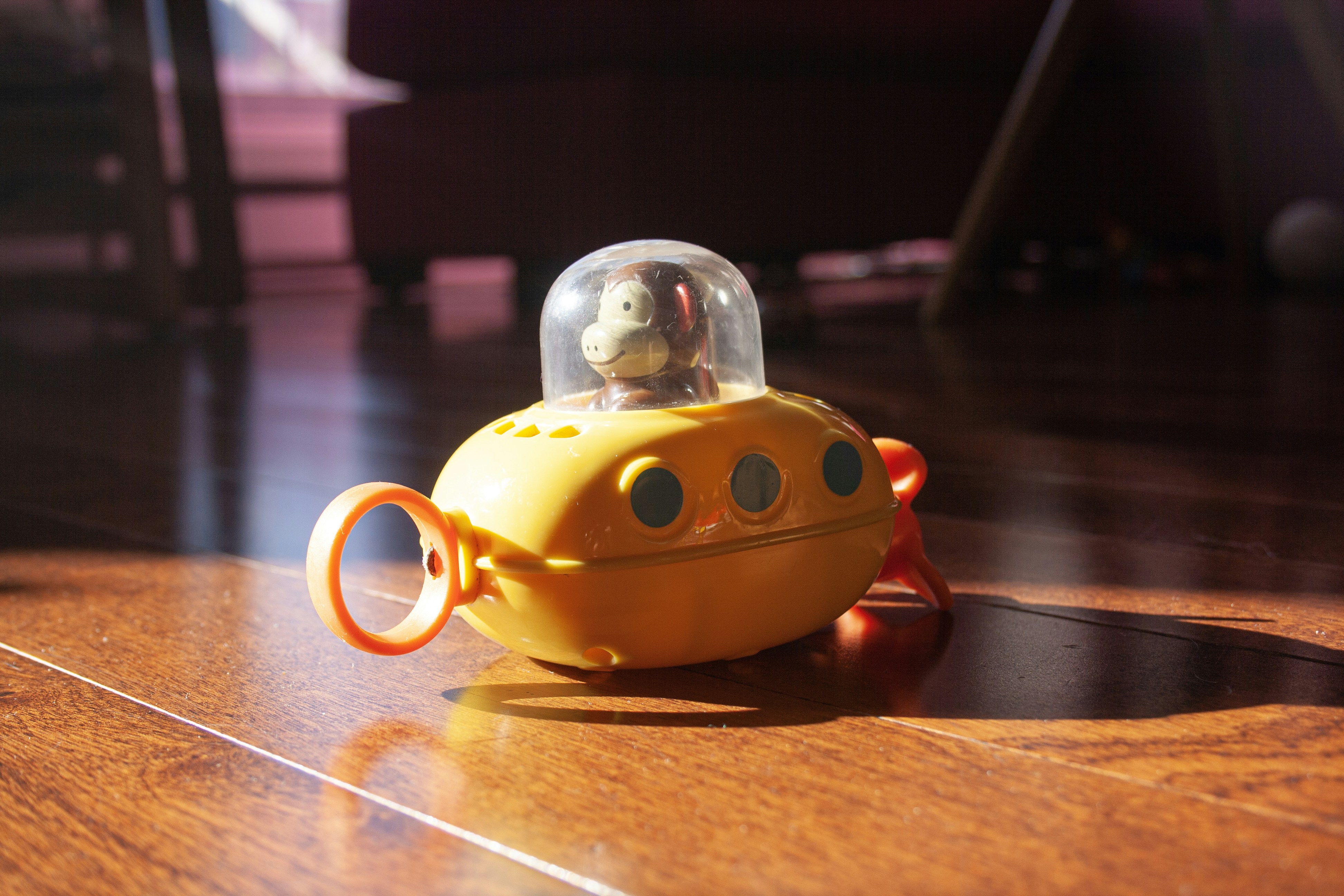 A yellow toy with a monkey inside of it