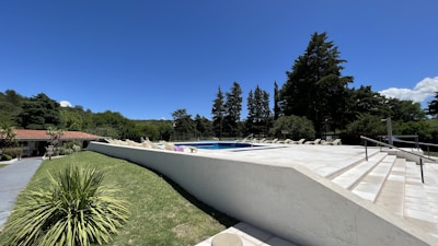 Elegant outdoor pool area at Trianon Clube during sunset with lush greenery surrounding.