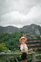 a woman in a hat standing on a wooden fence