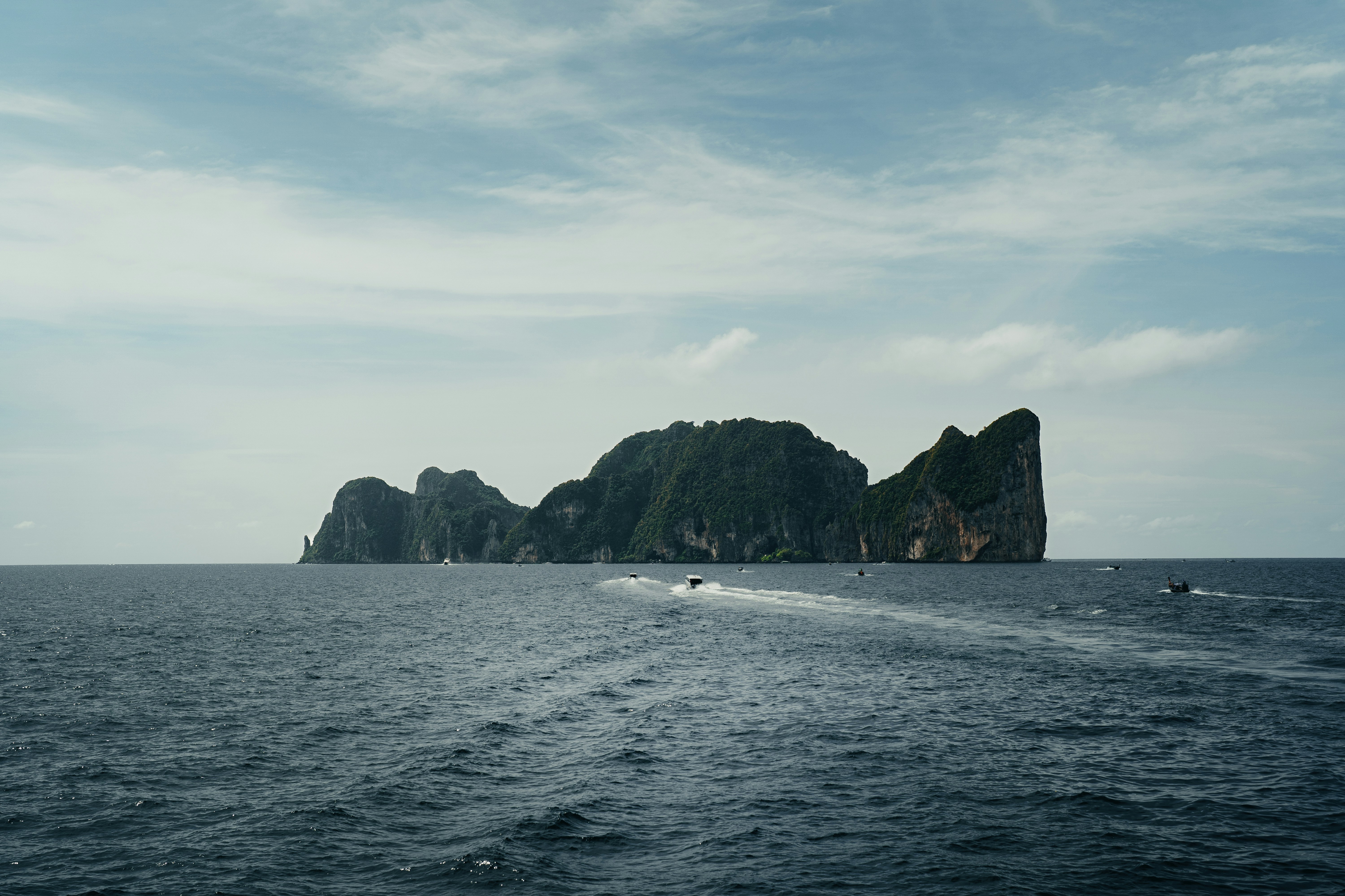 a boat is traveling through the water near some rocks
