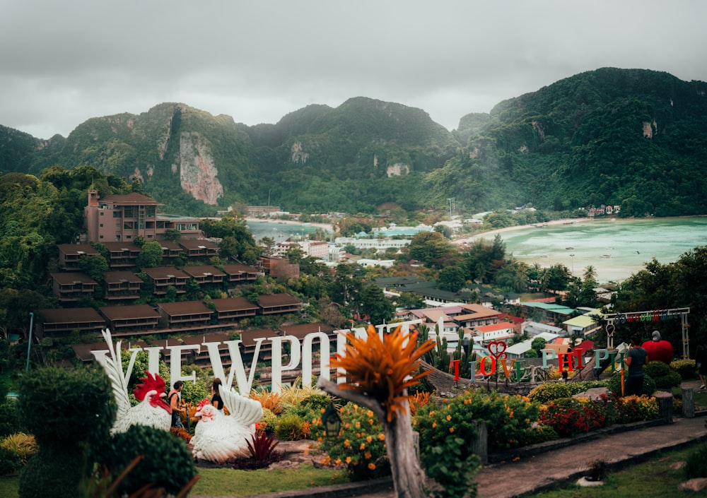 a scenic view of a town with mountains in the background