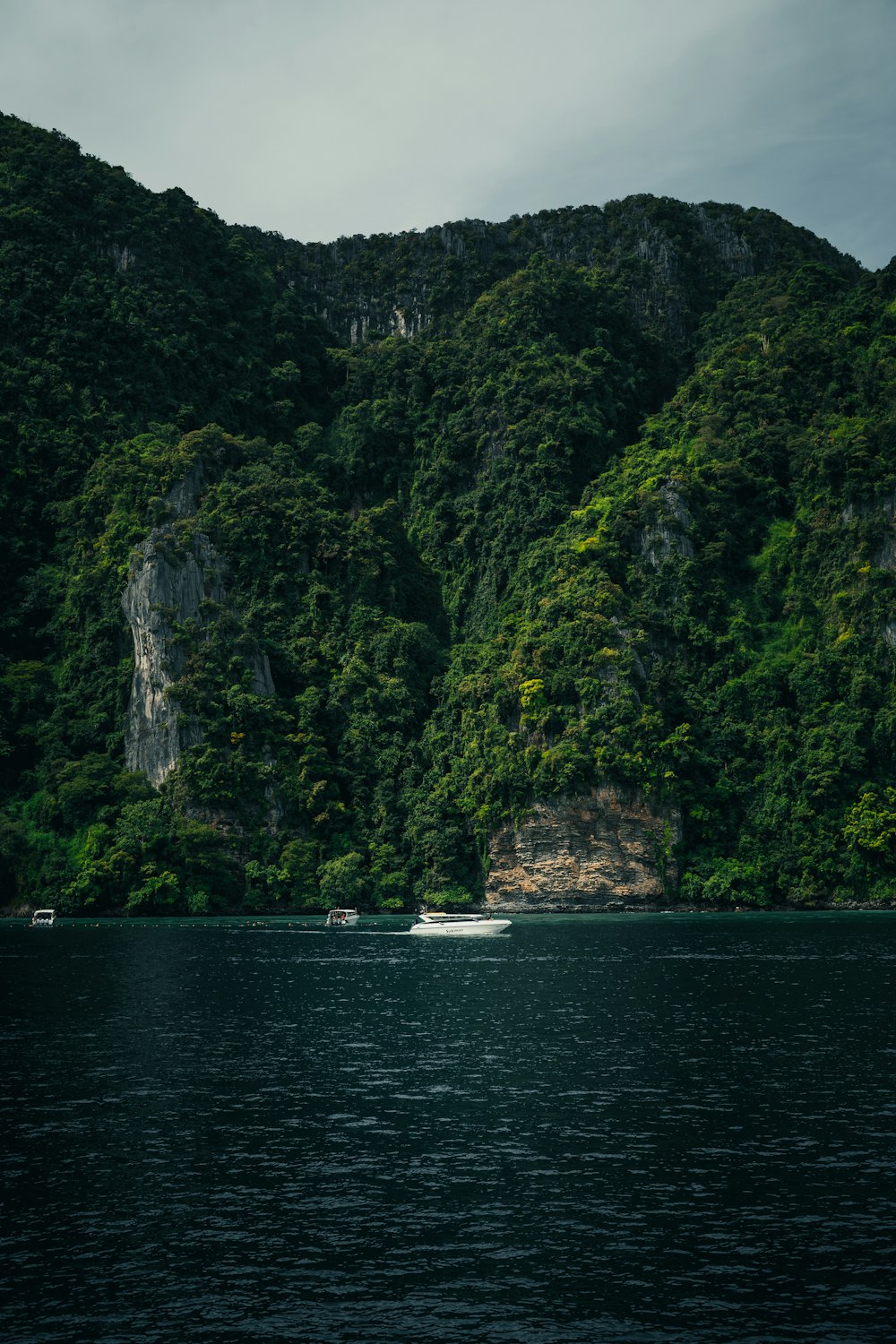 a boat in a body of water near a mountain