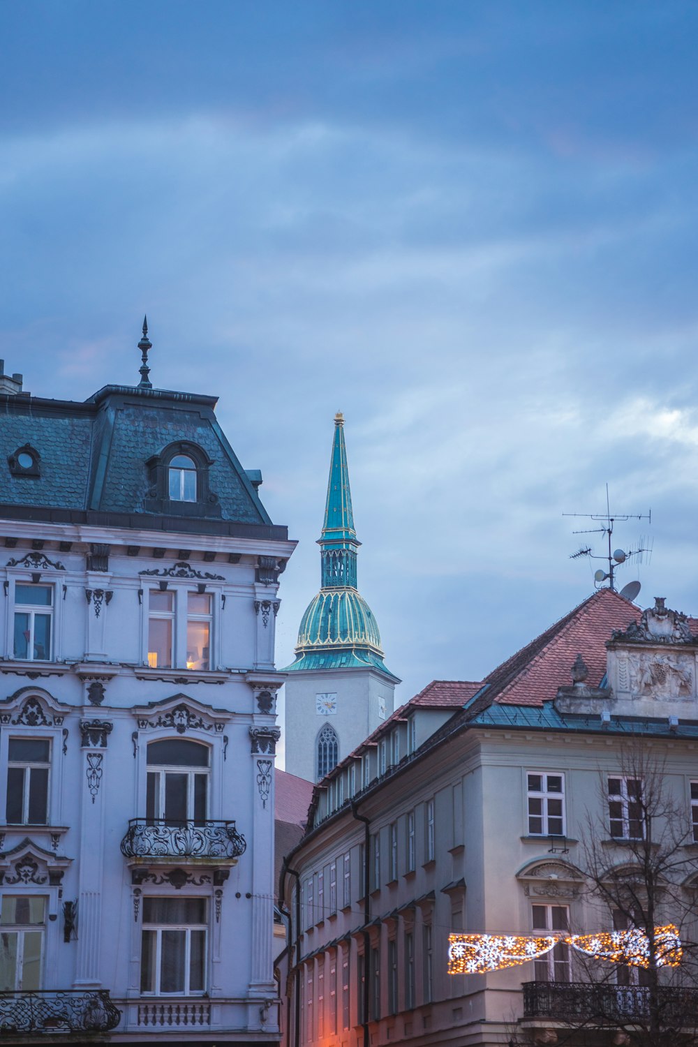 a tall building with a clock tower next to other buildings