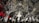 An elaborate interior featuring intricate mirrored ceilings and ornate chandeliers. The design includes geometric patterns, reflective surfaces, and detailed artwork. Warm lighting enhances the glass and metallic textures, creating a luxurious and sophisticated ambiance.