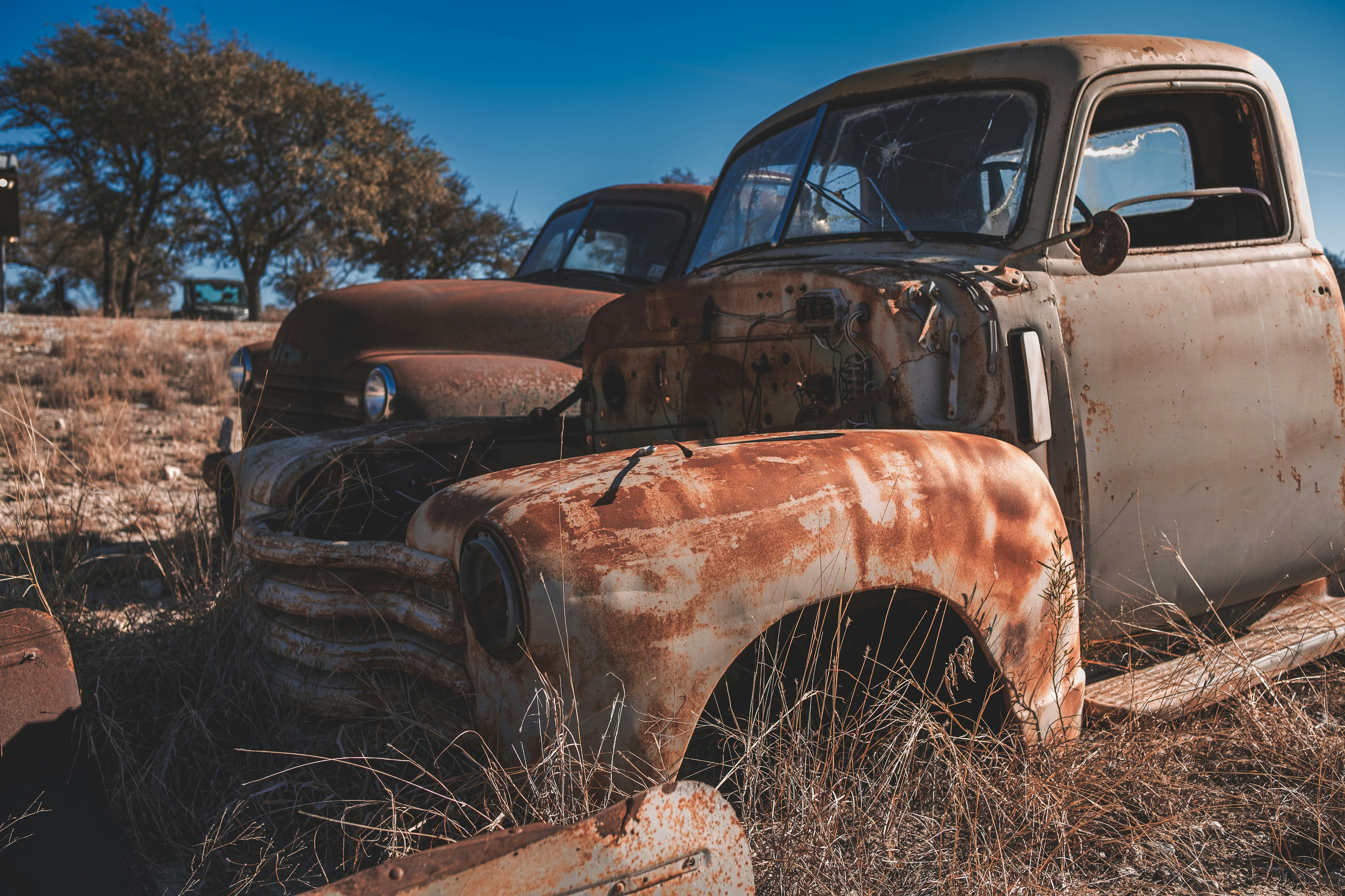 an old rusted truck sitting in a field