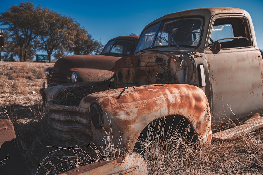 an old rusted truck sitting in a field