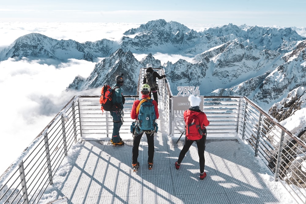 a group of people standing on top of a snow covered mountain