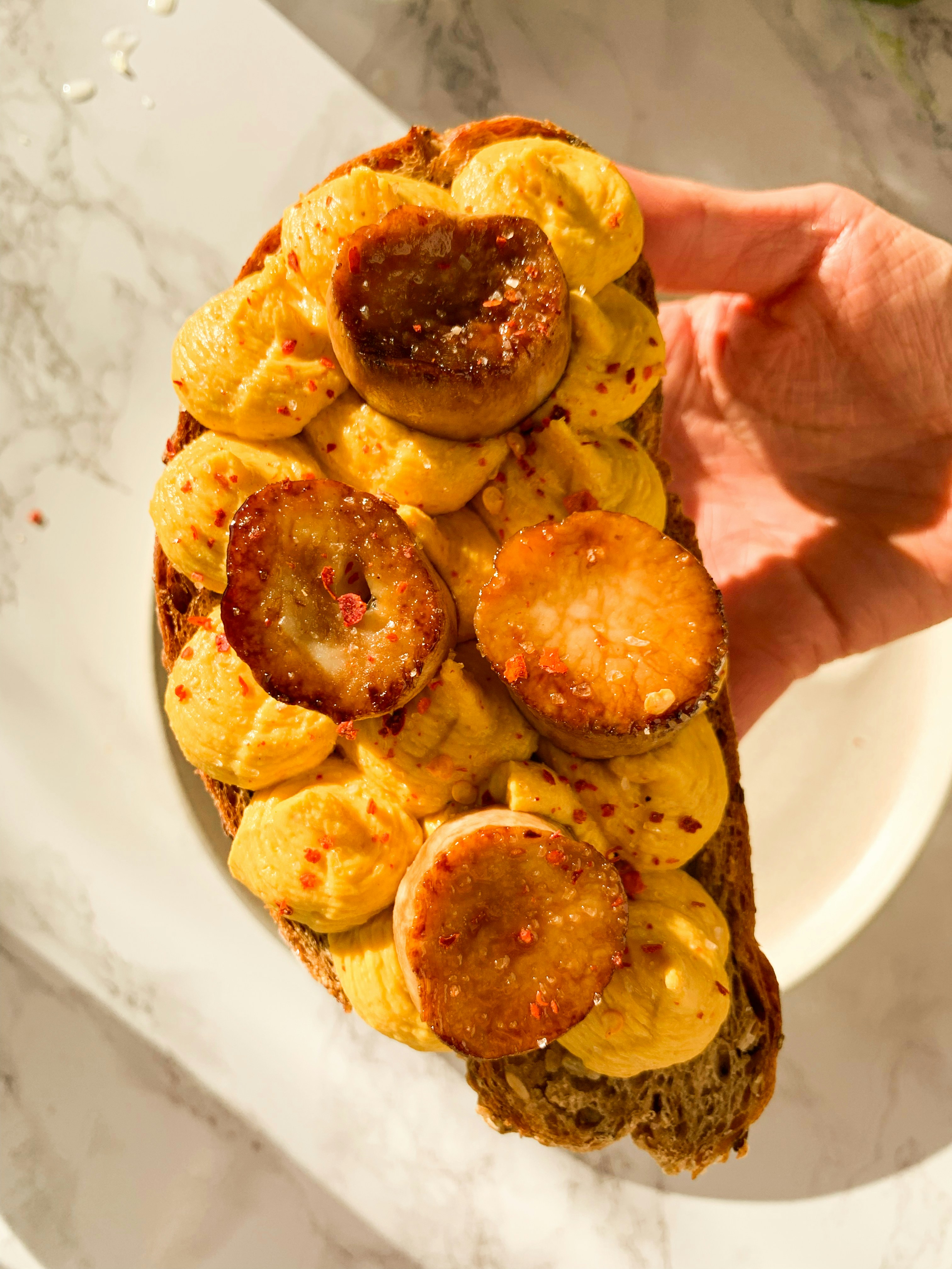 a person holding a piece of bread with bananas on it