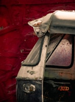 An old circus poster plastered on a rusty car door, faded but vivid.