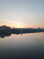 A peaceful morning scene of a city skyline with sunlight reflecting on buildings.