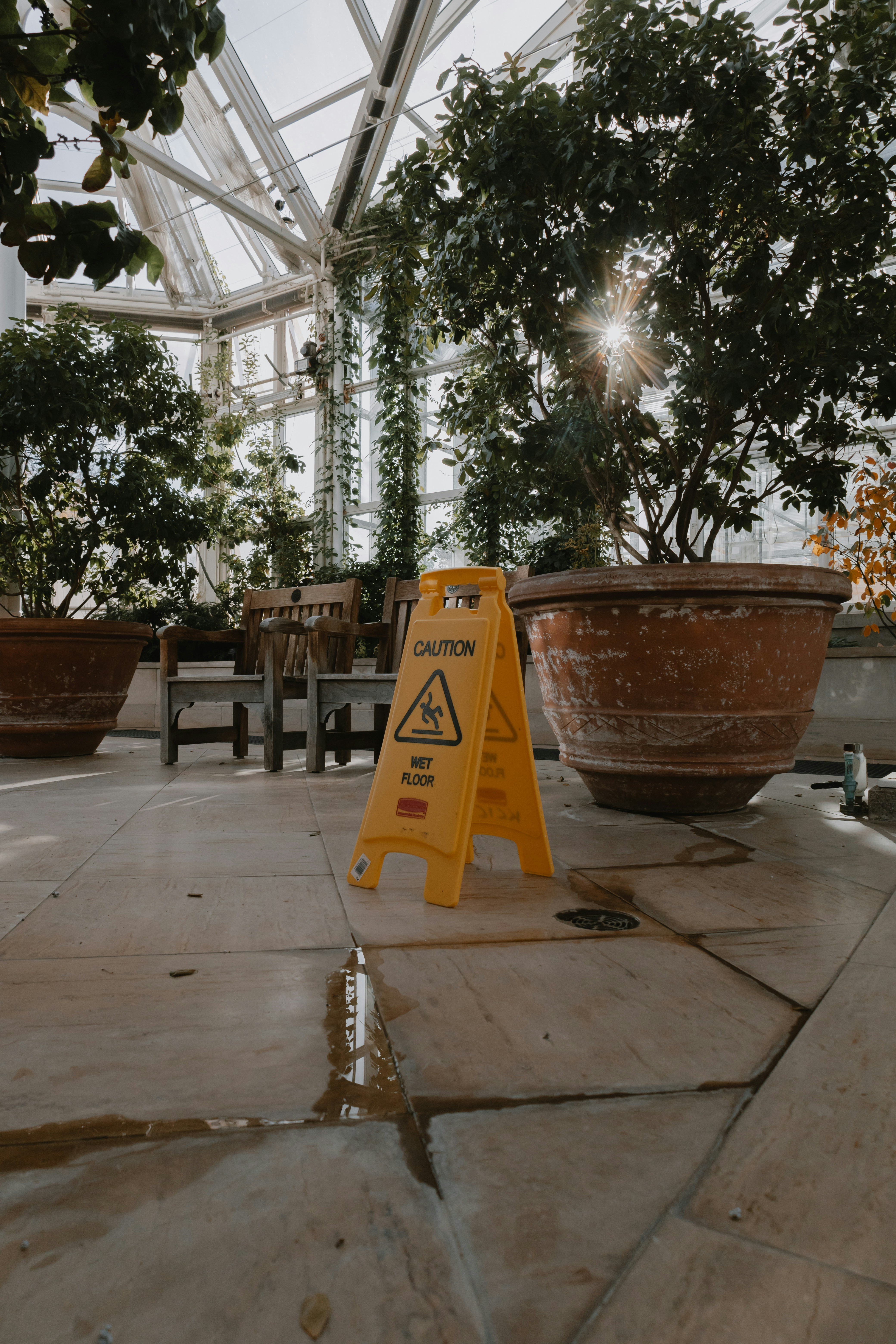 a yellow caution sign sitting on top of a tiled floor