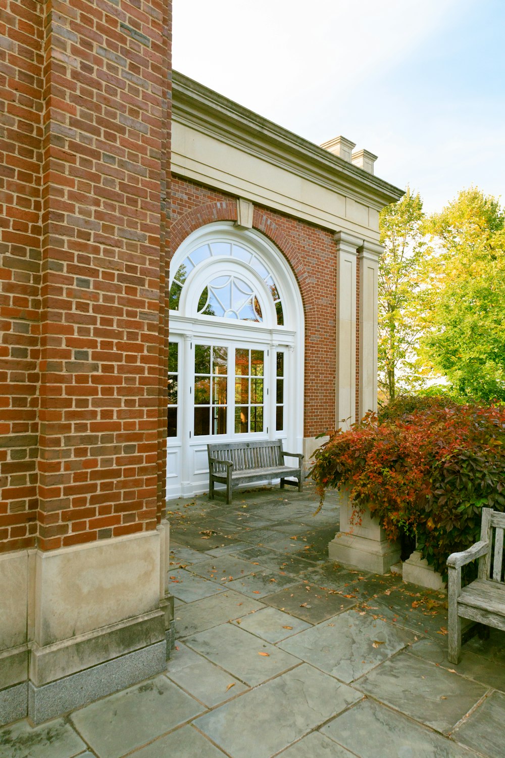 a wooden bench sitting next to a brick building