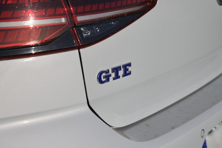 Close-up of a car's rear section with a partial view of the taillight and the GTE badge prominently displayed on the vehicle's body, indicating a hybrid or electric model.
