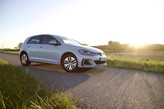 A comfortable car parked near a scenic countryside road at sunset.