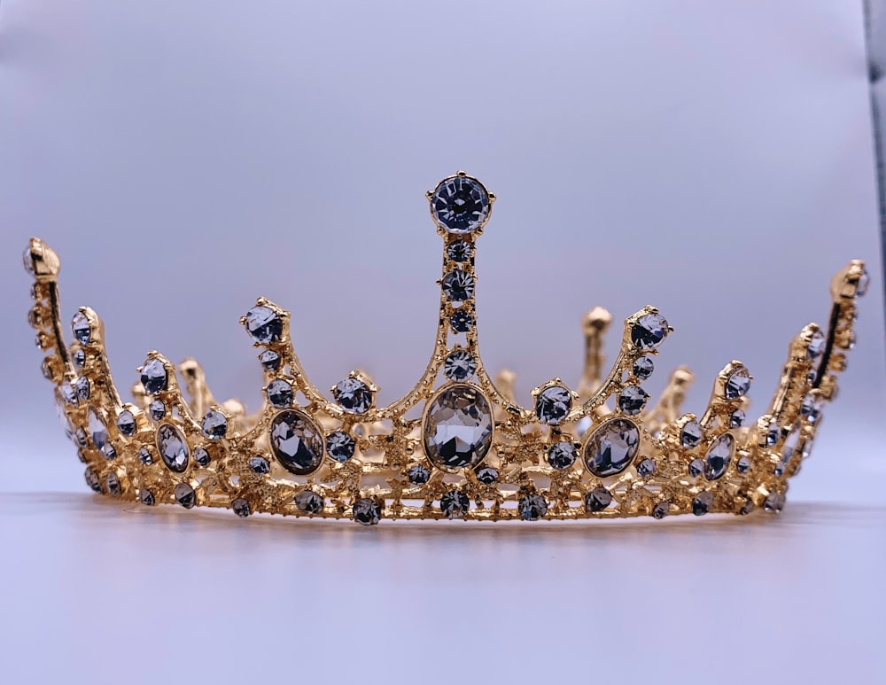 a gold crown with black and white stones