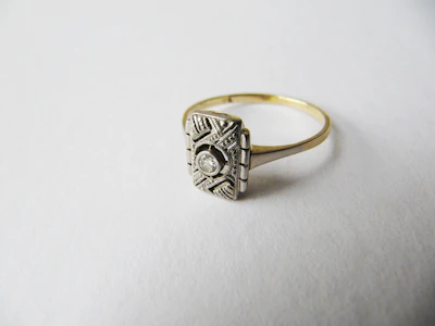 Vintage-inspired ring featuring ornate scrollwork and a large gemstone centerpiece.