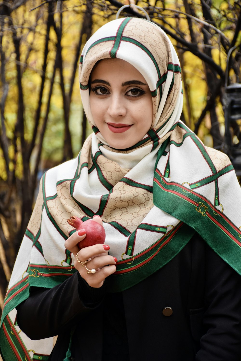 a woman in a hijab holding an apple