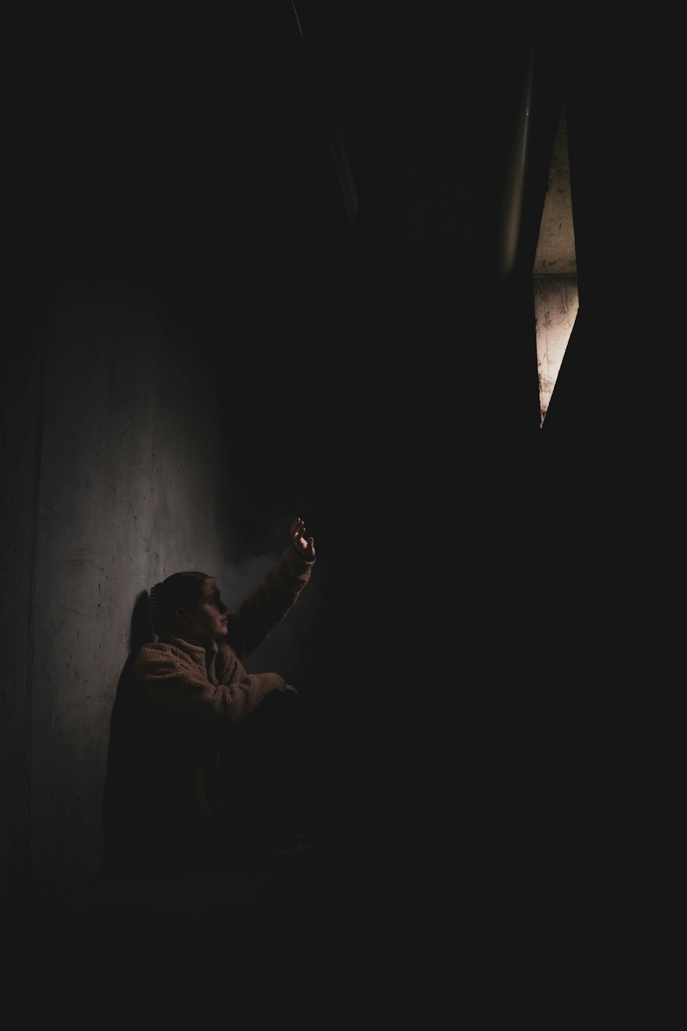 a person standing in a dark room holding a cell phone