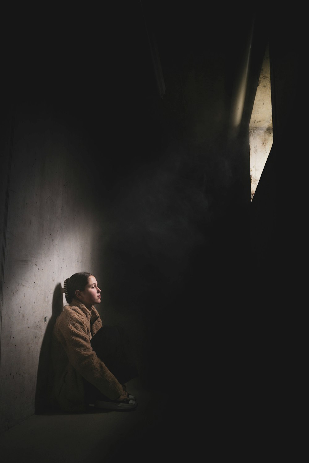 a woman sitting on the ground in the dark