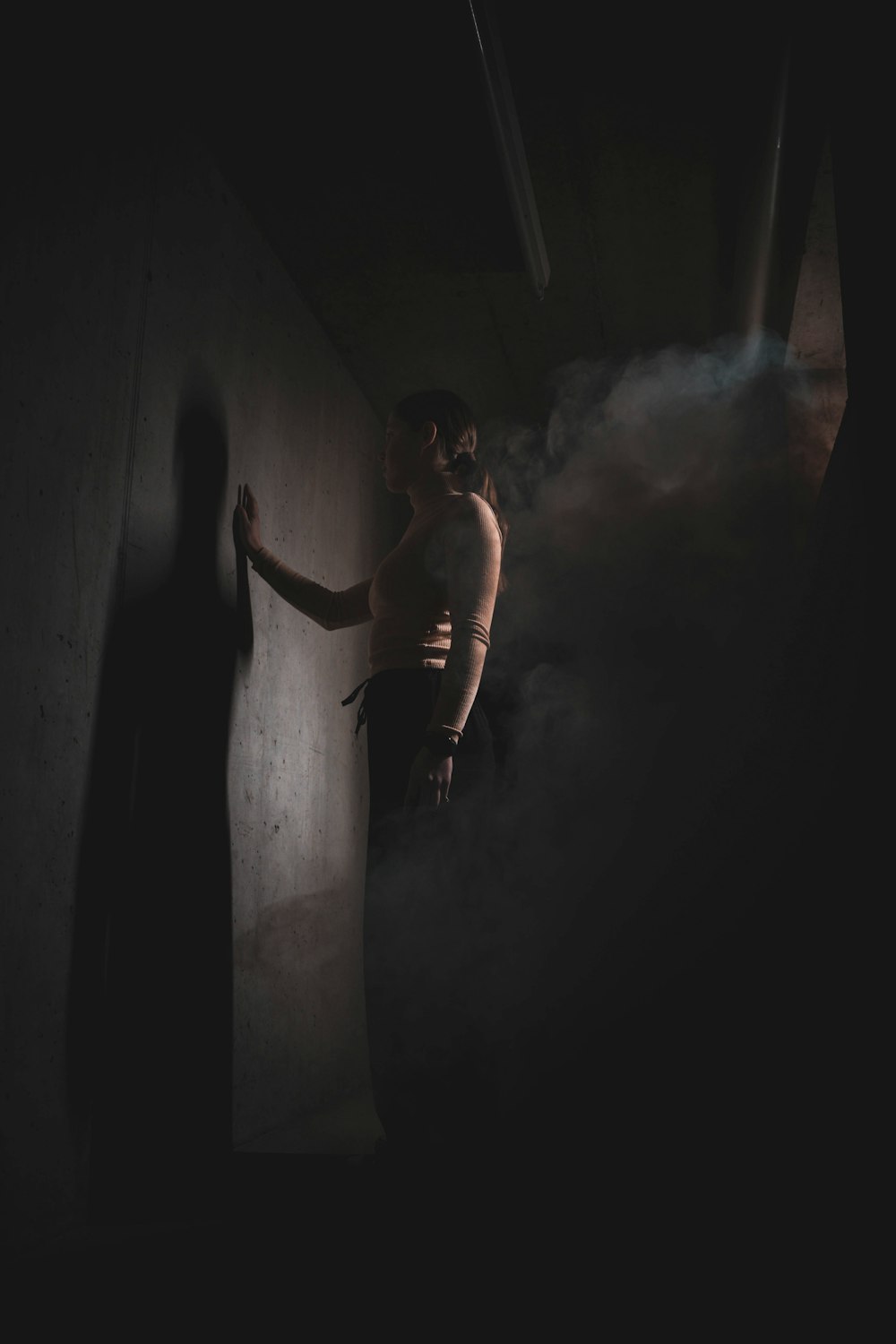 a man standing in a dark room with smoke coming out of the walls