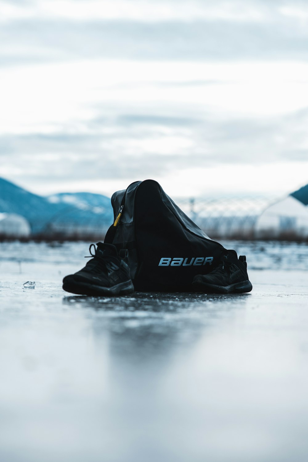 a pair of black shoes sitting on top of an ice covered ground