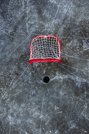 An empty hockey goal on a freshly cut sheet of ice before a game