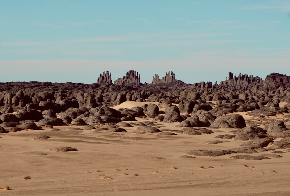 a desert landscape with rocks and sand in the foreground