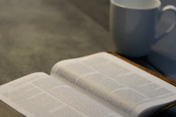 A serene setting with an open Bible and a journal beside a cup of tea, symbolizing life coaching.